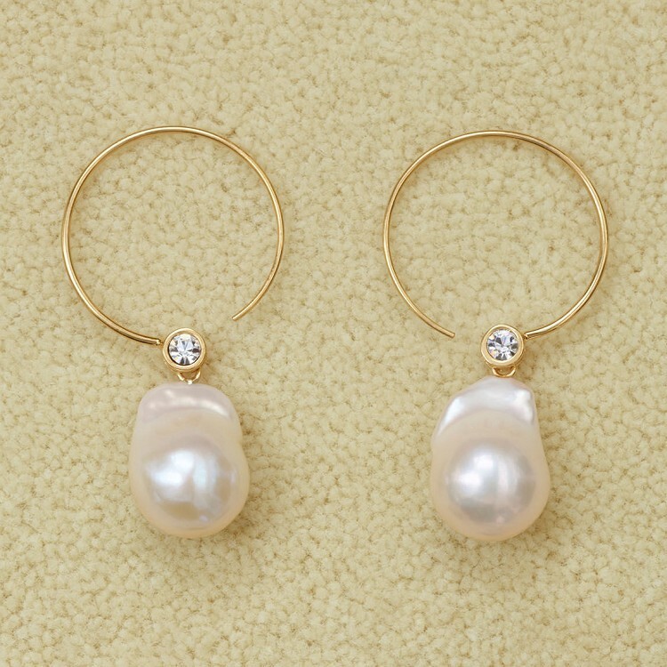 Detailed view of Céline Baroque pearl earrings showcasing pearl and brass craftsmanship