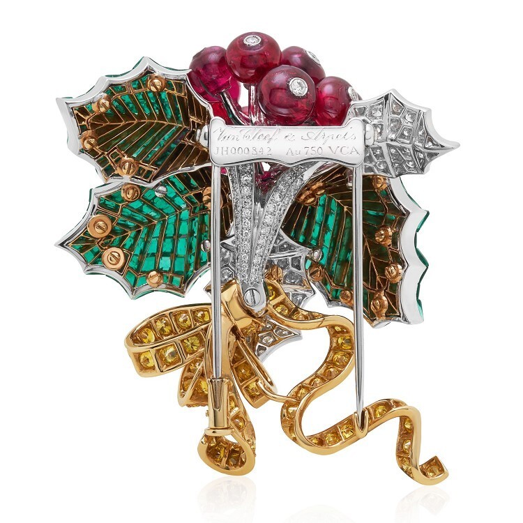 Another view of the Van Cleef & Arpels Houx Mystérieux brooch, highlighting the vibrant contrast between red spinel and green emeralds.