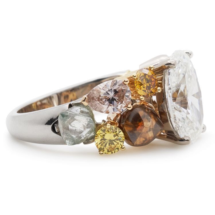 Detailed shot of the De Beers Soothing Lotus ring's craftsmanship, focusing on the various diamond cuts and colors.