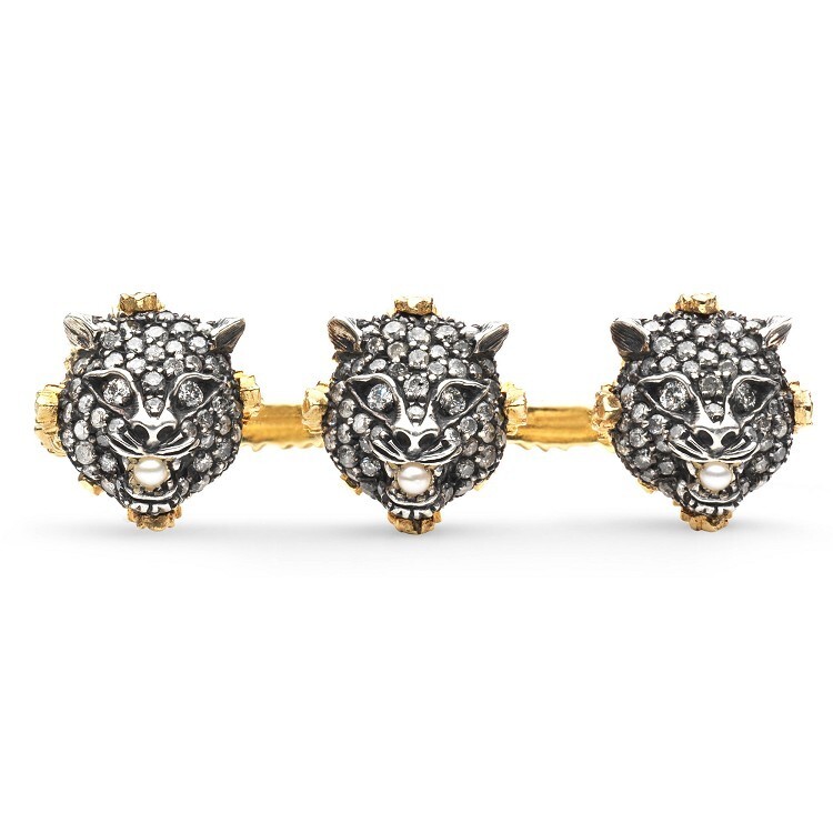 Close-up of Gucci Lion Head Ring, featuring aged silver, intricate diamond setting, and a prominent white pearl in its mouth