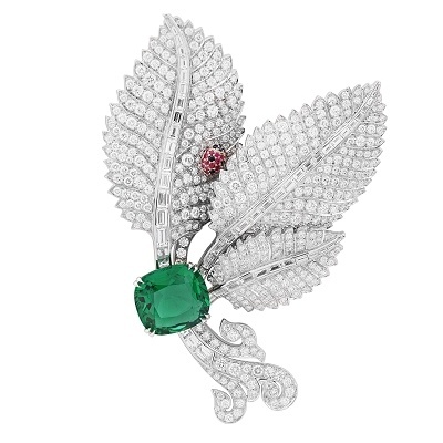 Close-up view of the Van Cleef & Arpels 'Cachette des Coccinelles' brooch open, revealing the hidden rose gold and spinel ladybug nestled among diamond-encrusted palm leaves.