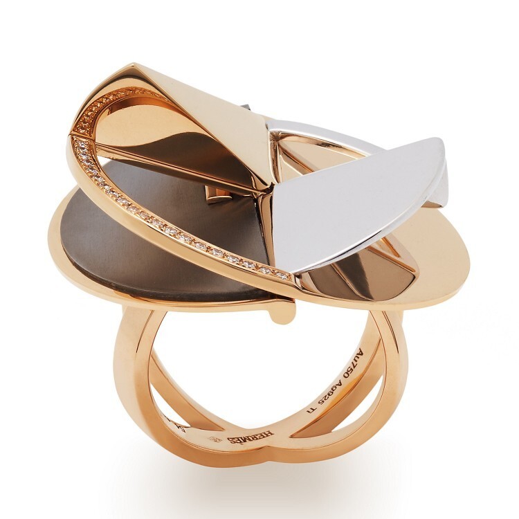 Detailed shot of the Hermès Trajectoire ring, emphasizing the round-cut diamonds on the rose gold disc.
