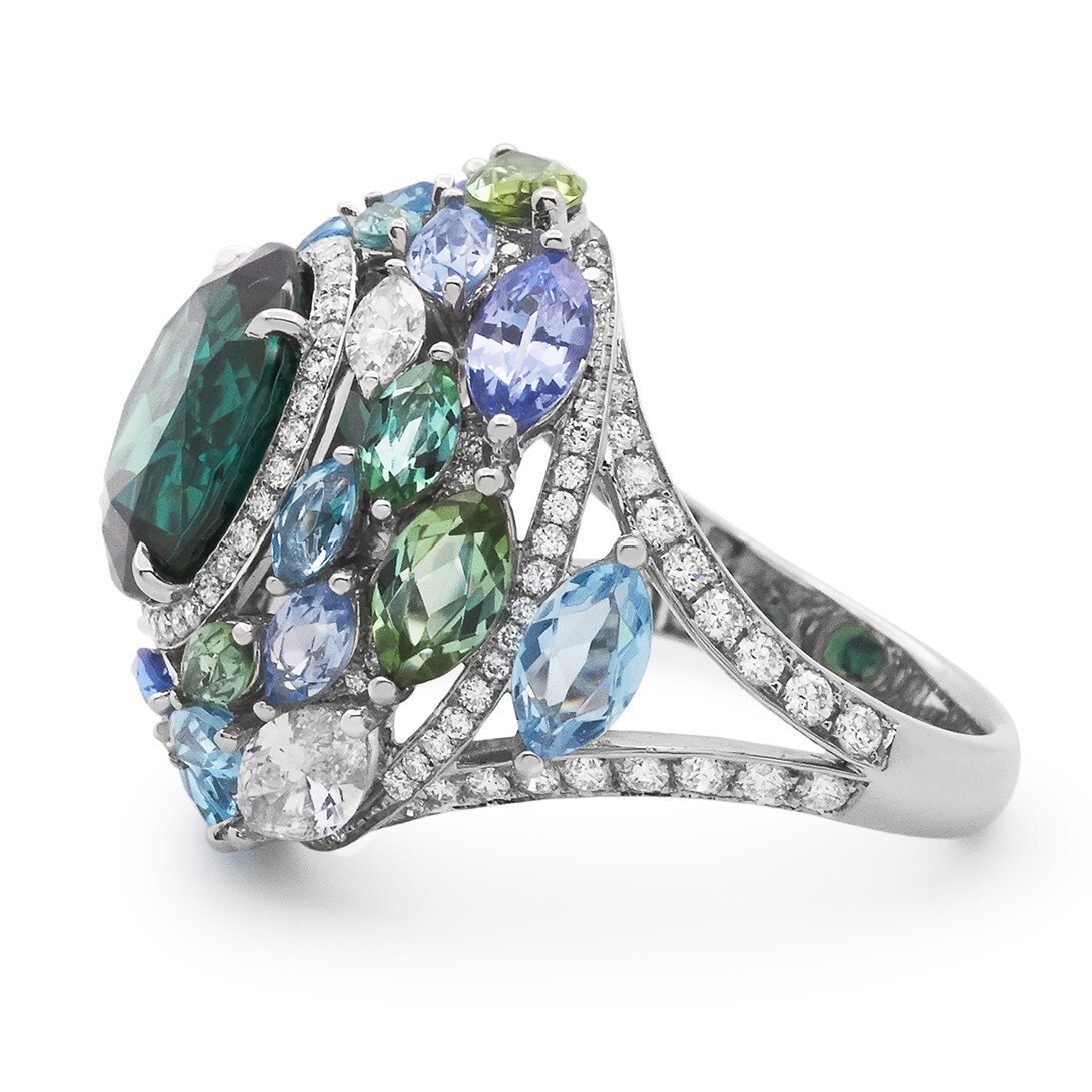 Detailed shot of the marquise-cut green tourmalines, aquamarines, sapphires, and diamonds encircling the central green tourmaline.