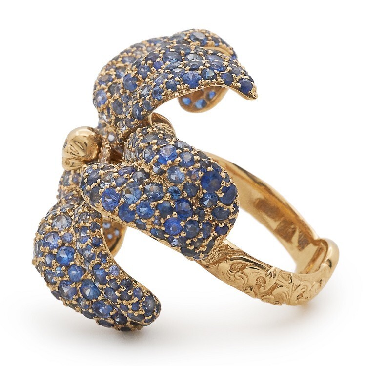Detailed view of the Gucci Flora lily ring, highlighting the golden eagle skull stamen with sapphire eyes