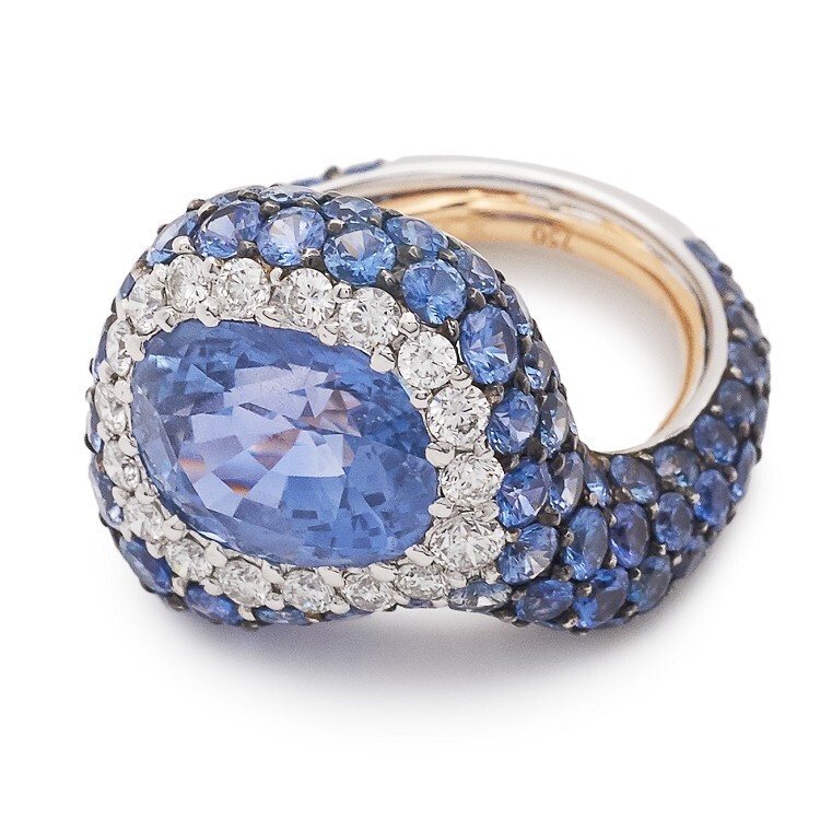 Angled perspective of the de Grisogono high jewellery ring, showing the asymmetrical design and the tilted central sapphire.