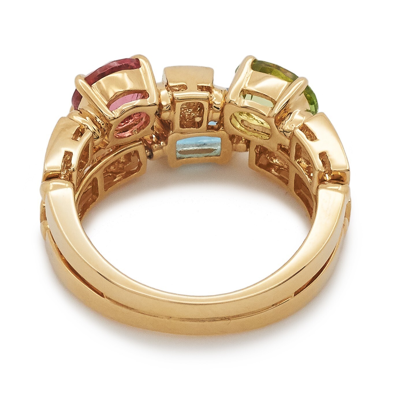 Bulgari Allegra Color ring displaying an emerald-cut blue topaz, round-cut pink tourmaline, and oval-cut green peridot on a gold band.