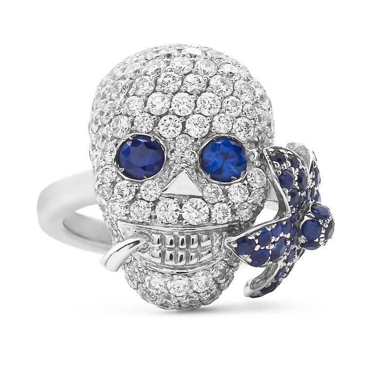 Detailed close-up of the Gucci Flora Lily Skull Ring, highlighting the intricate diamond-set skull and vibrant sapphire flora.