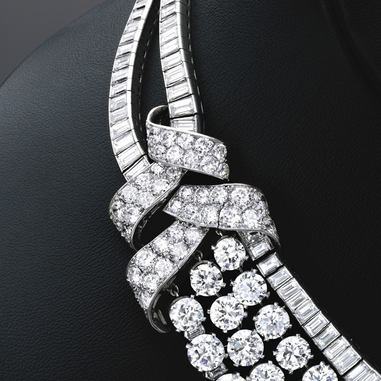 The elegant drape of a Van Cleef & Arpels diamond necklace adorned with numerous gemstones.