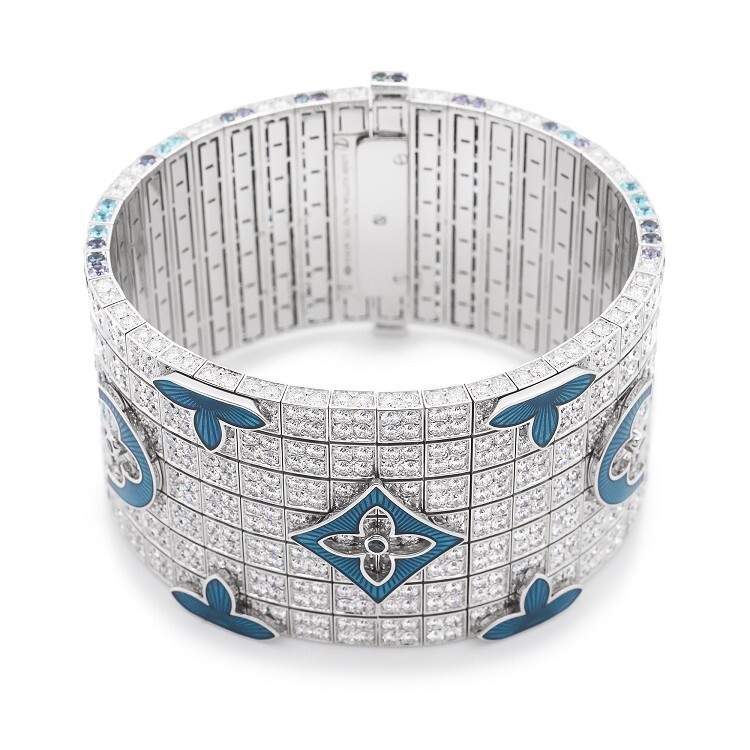 Detailed view of the Louis Vuitton 'Voyage dans le temps' bracelet, highlighting the intricate blue enamel and diamond settings on the Monogram side.
