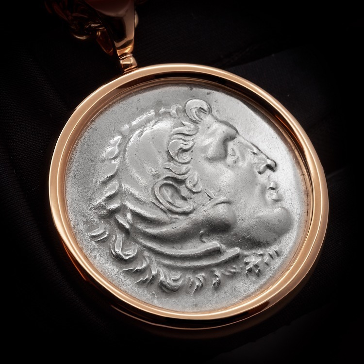 Close-up view of the ancient silver coin centerpiece of the Bulgari Monete pendant, depicting Hercules.